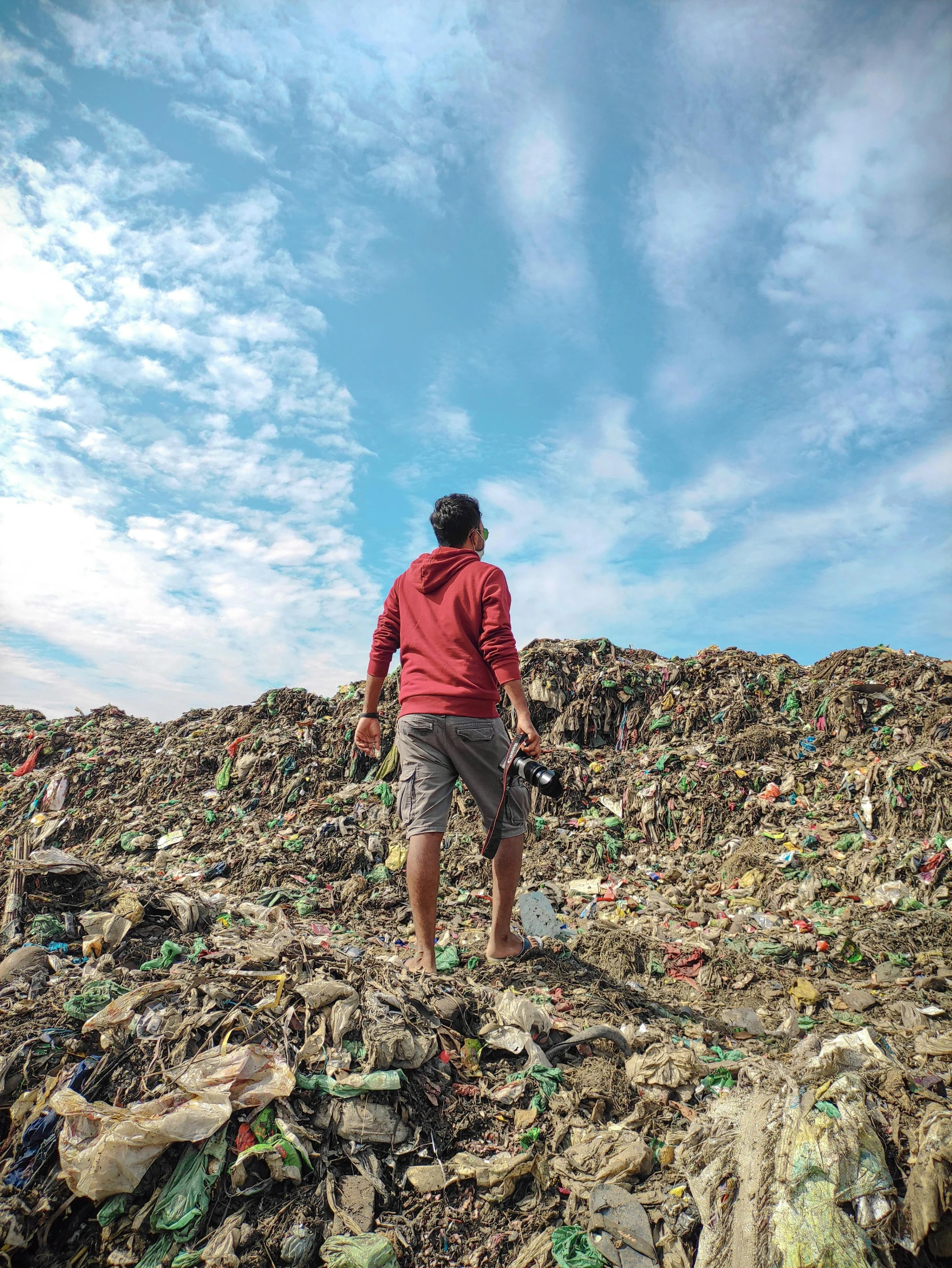 the man is standing on a mountain full of trash