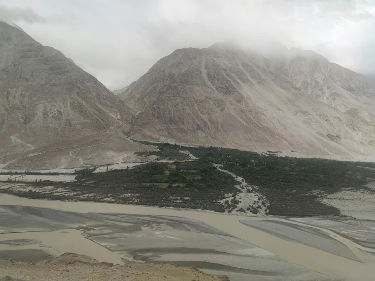 the mountains are barren with a snow covered road