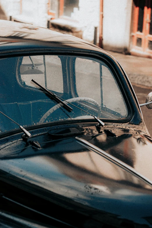 an old time car sits in front of a small white building