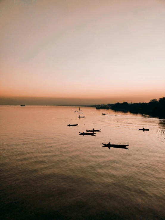 a body of water with a boat and several canoes floating in it