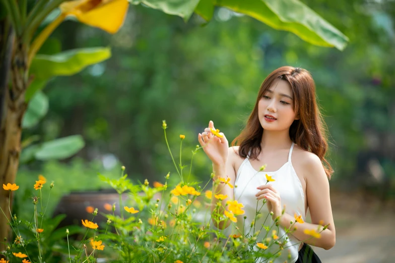 a girl standing among flowers in a park