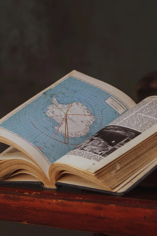 an open book with maps is on the table