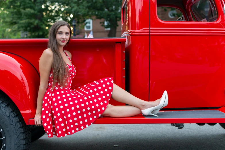 the girl is posing for a po in front of her vintage truck