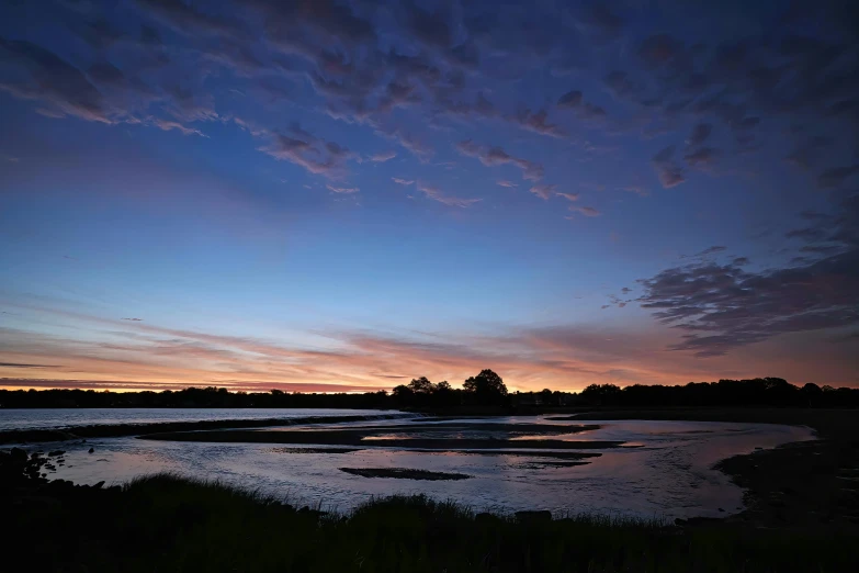 beautiful sunset over lake with purple cloud cover