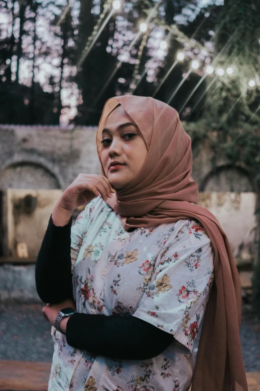 an older woman wearing a hijab is walking in the woods