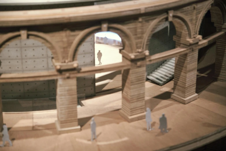 two people walking near an architecture model of a train station