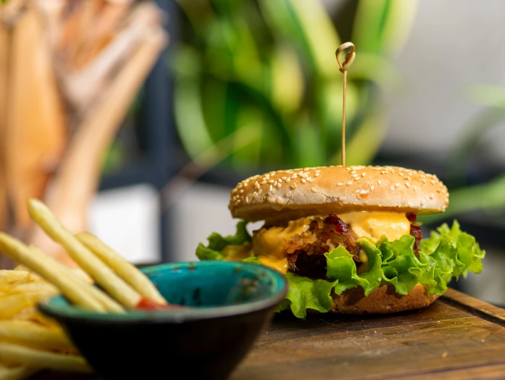 a burger with lettuce and tomato on it with french fries