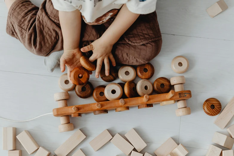 a  playing with wooden toys while sitting on the floor