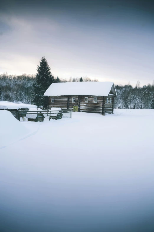 the old cabin is still sitting in the deep snow