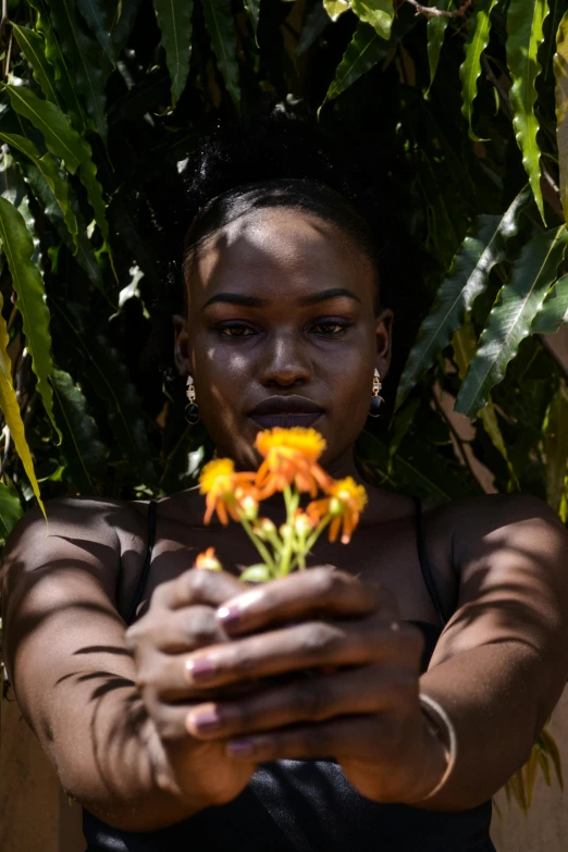 a woman holding out flowers while looking at the camera