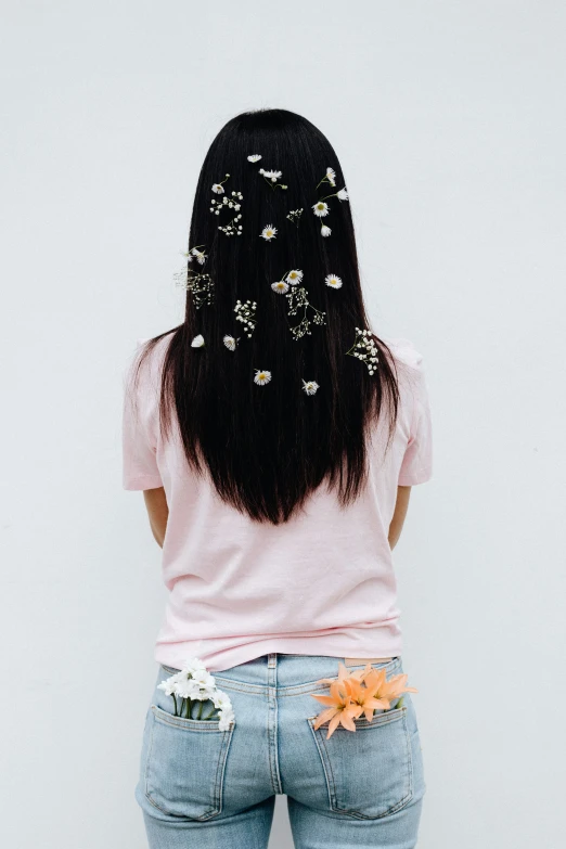 woman's back view of long straight hair with tiny flowers on her body