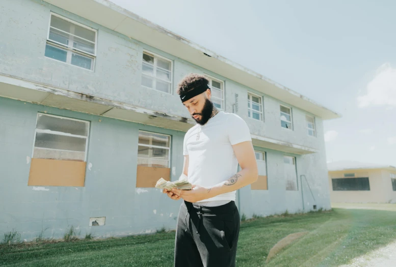 a man with tattoos standing in front of an empty building