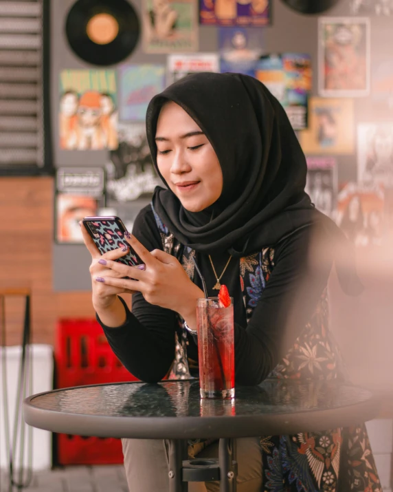 woman sitting in chair using smart phone at table