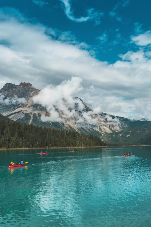 three canoes are in a lake that has blue and green water