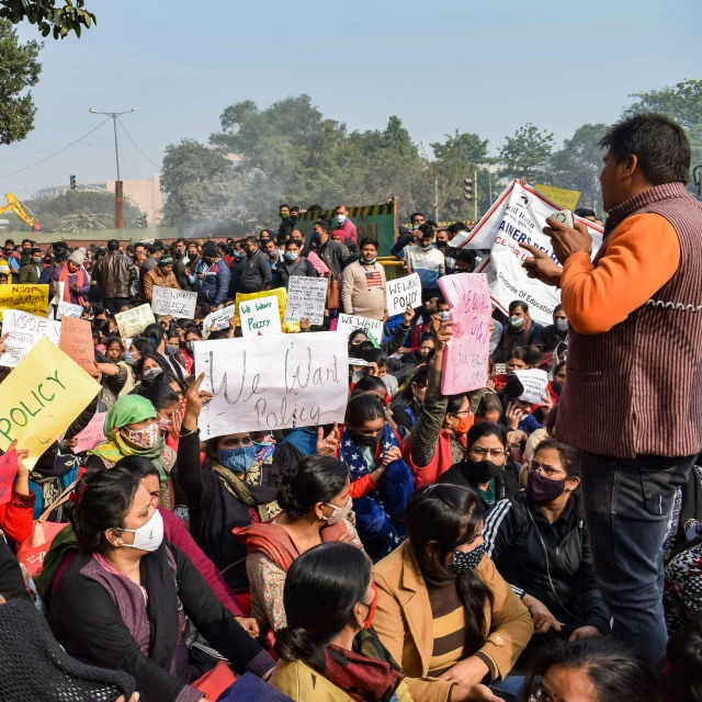 a group of people with protest signs sitting on the ground