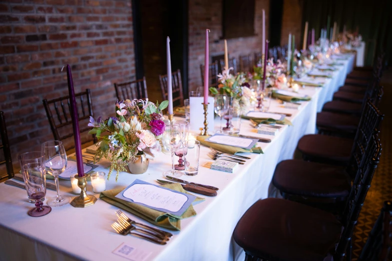 a long dining table set with plates and place settings