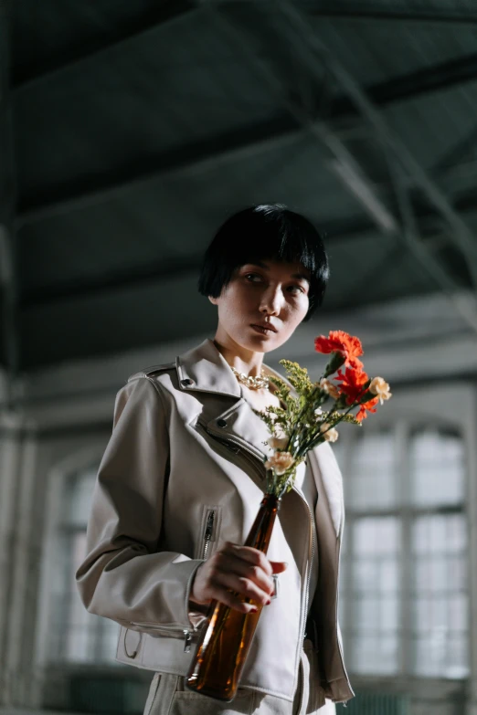 woman with a large flower holding a beer