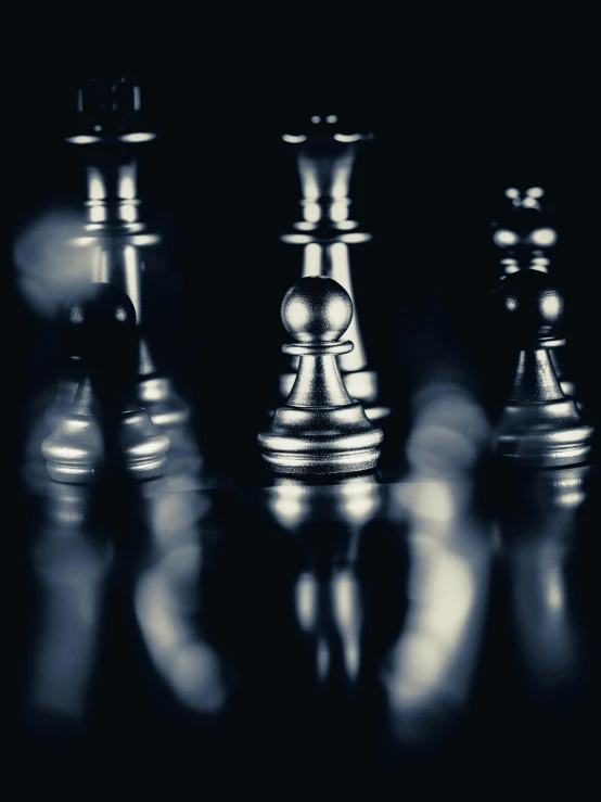 an illuminated black chess piece on dark surface