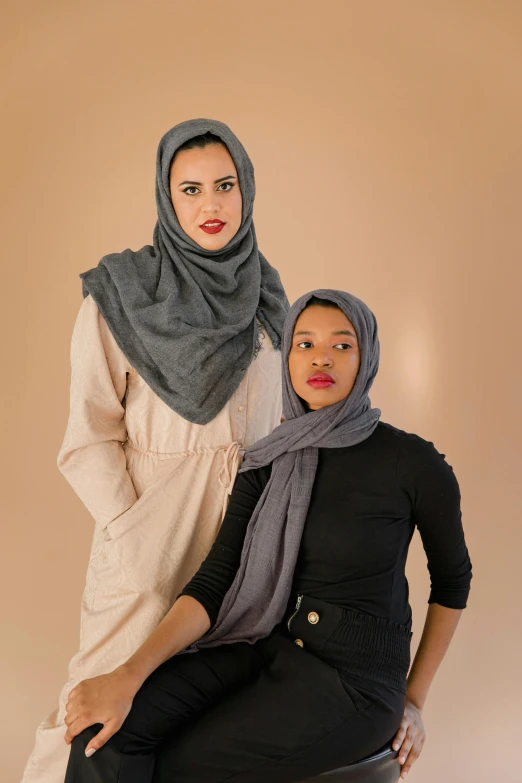two people are wearing hijabs and standing in a po studio