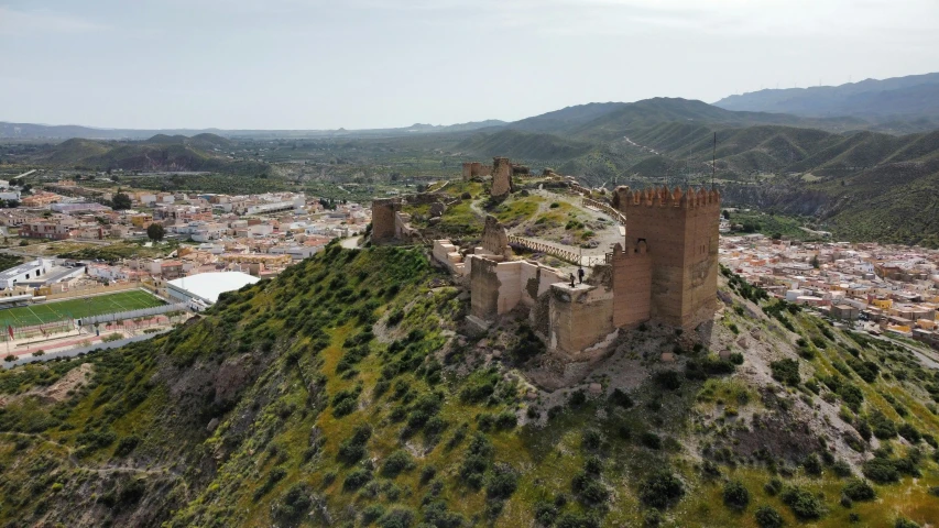 an aerial po of a castle atop a hill