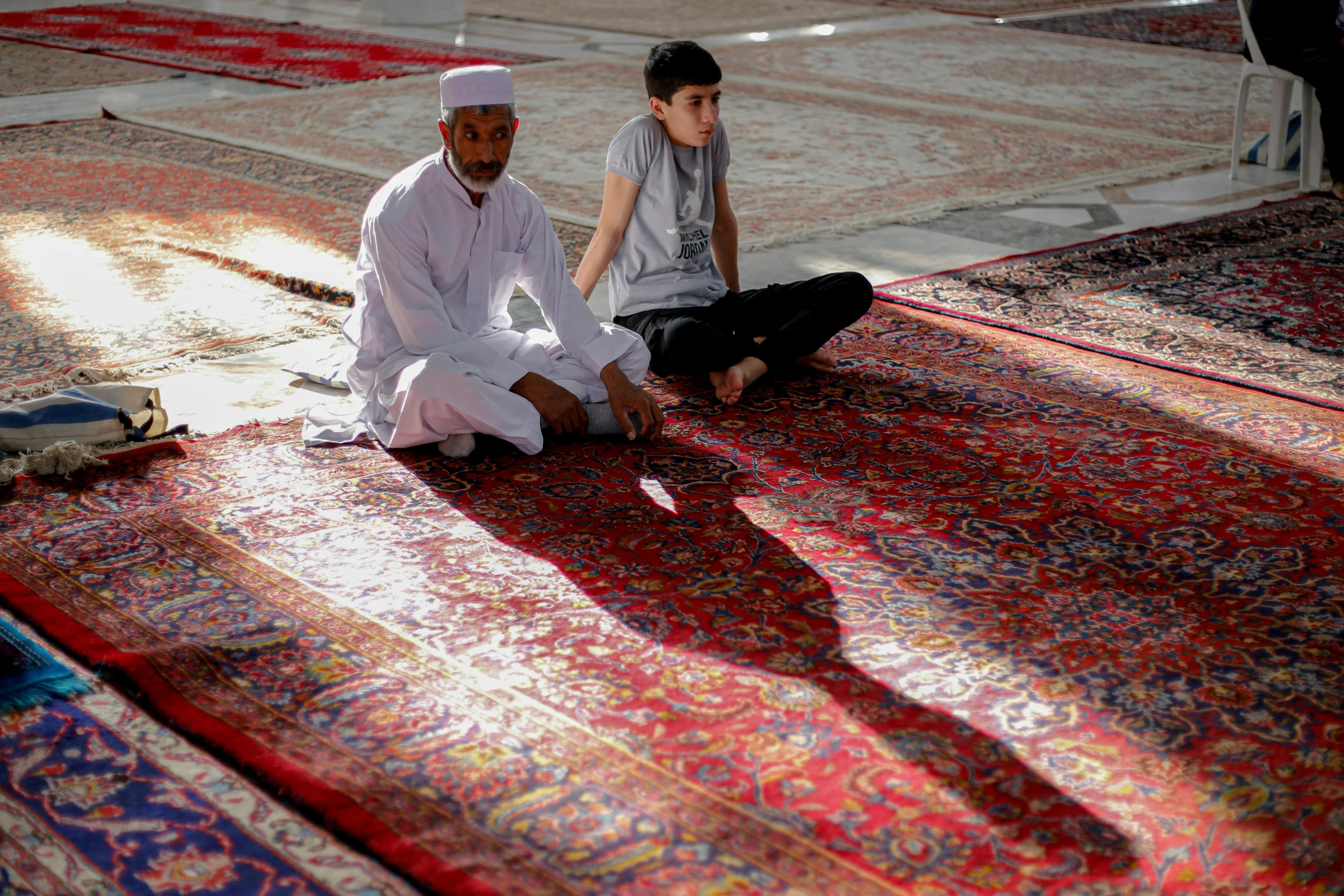 there is a little boy and man sitting on the ground