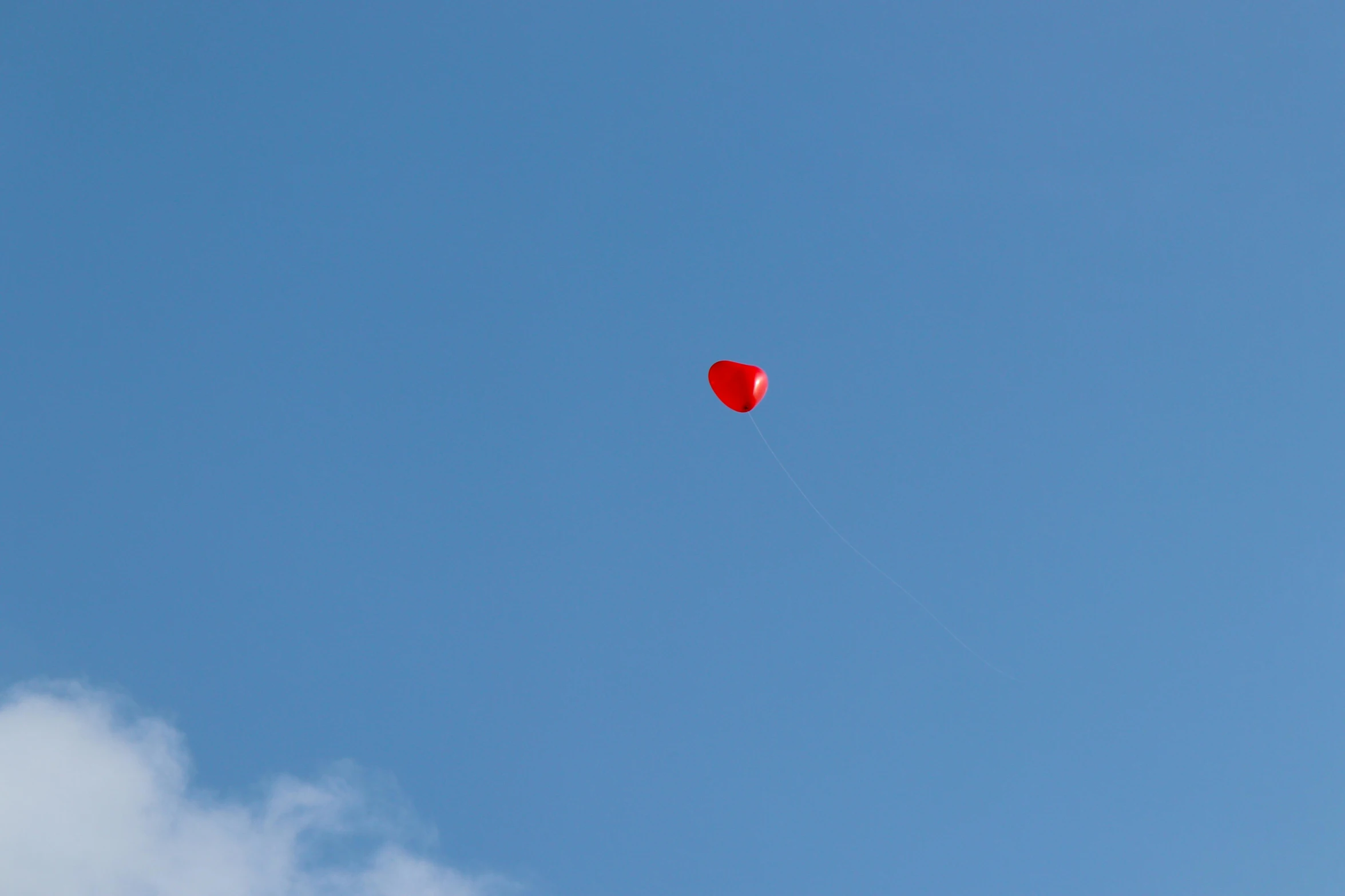 a small kite flying in the sky near some clouds