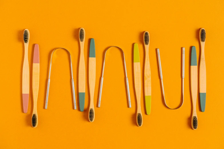 five toothbrushes lined up on a yellow surface