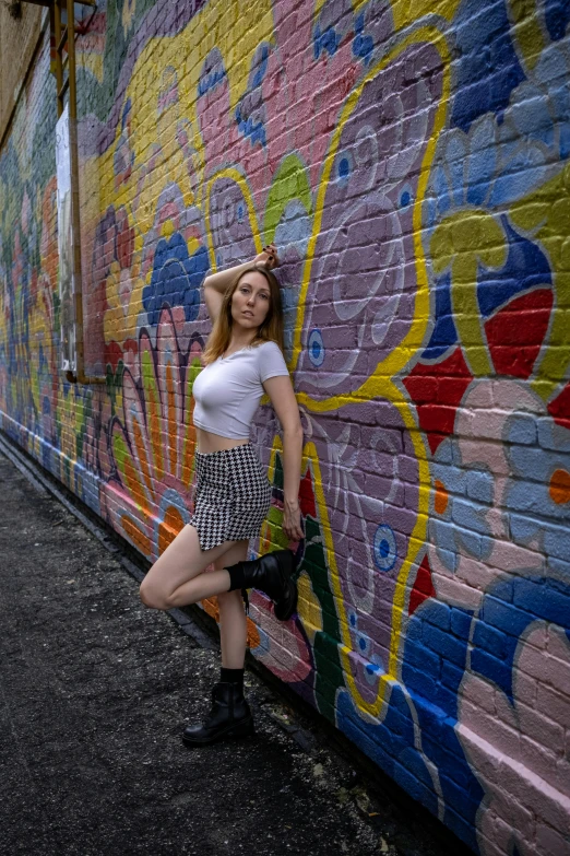 a woman is leaning against a wall with her head on the wall