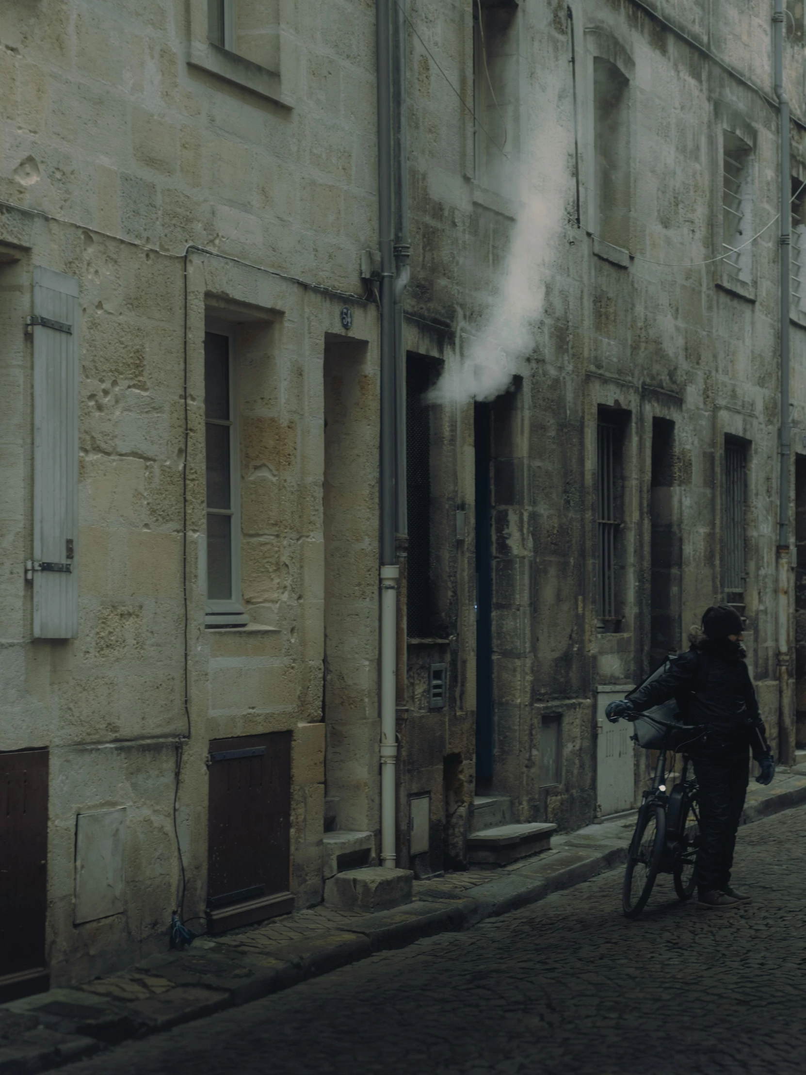 someone is riding their bike on a narrow street