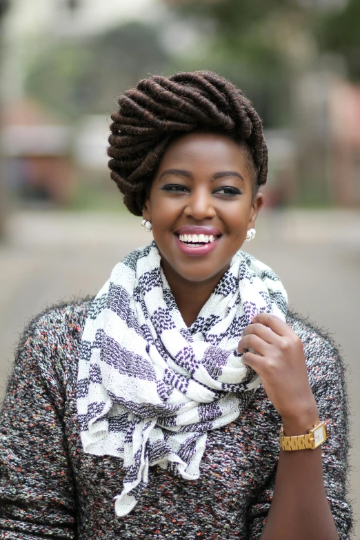 a woman in a scarf and watch standing on the street