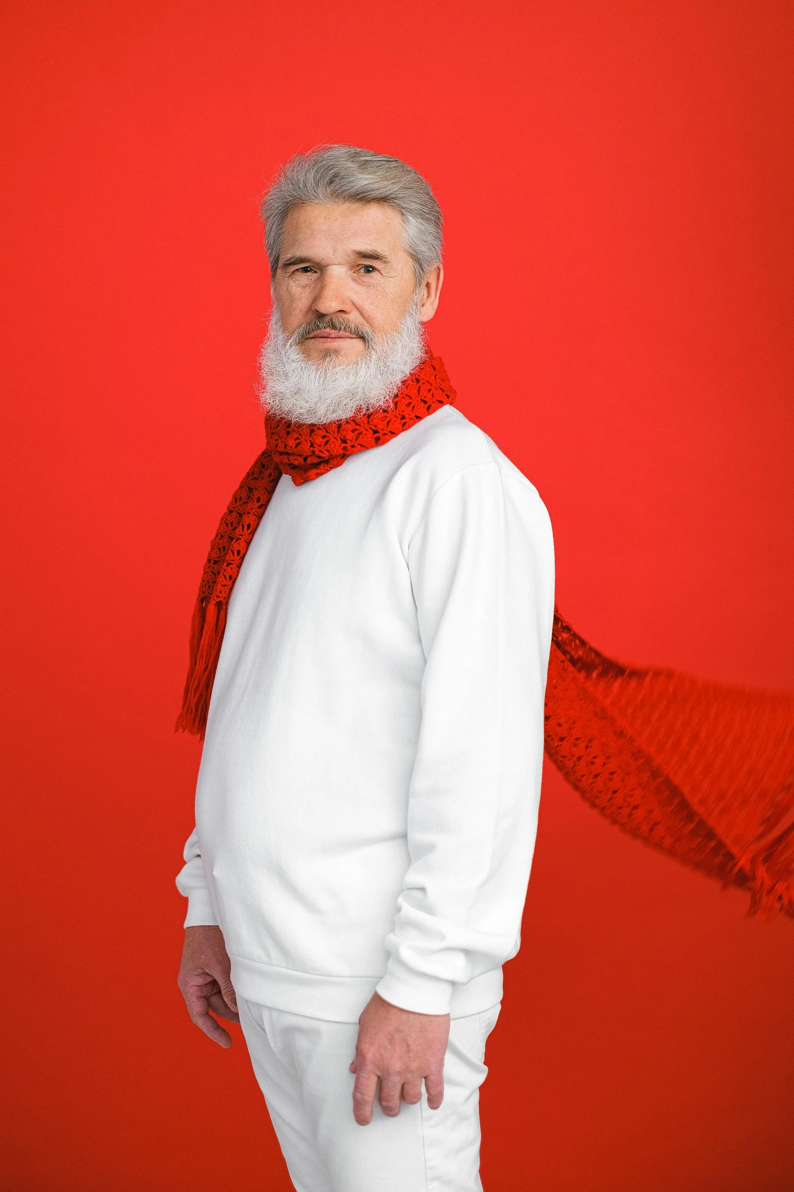 a man in white pants and a red scarf