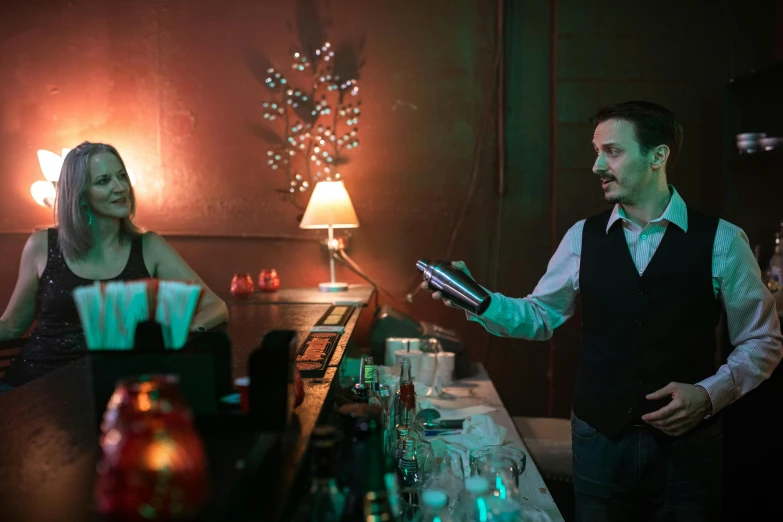 the man and woman are standing in front of the bar