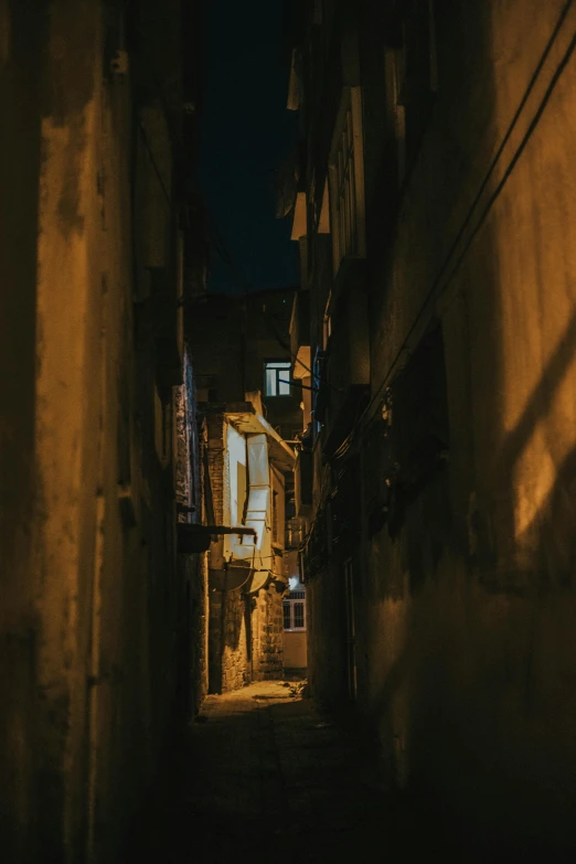 an alley way with dark buildings and windows