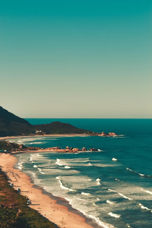 the view from above of a beach next to a hill