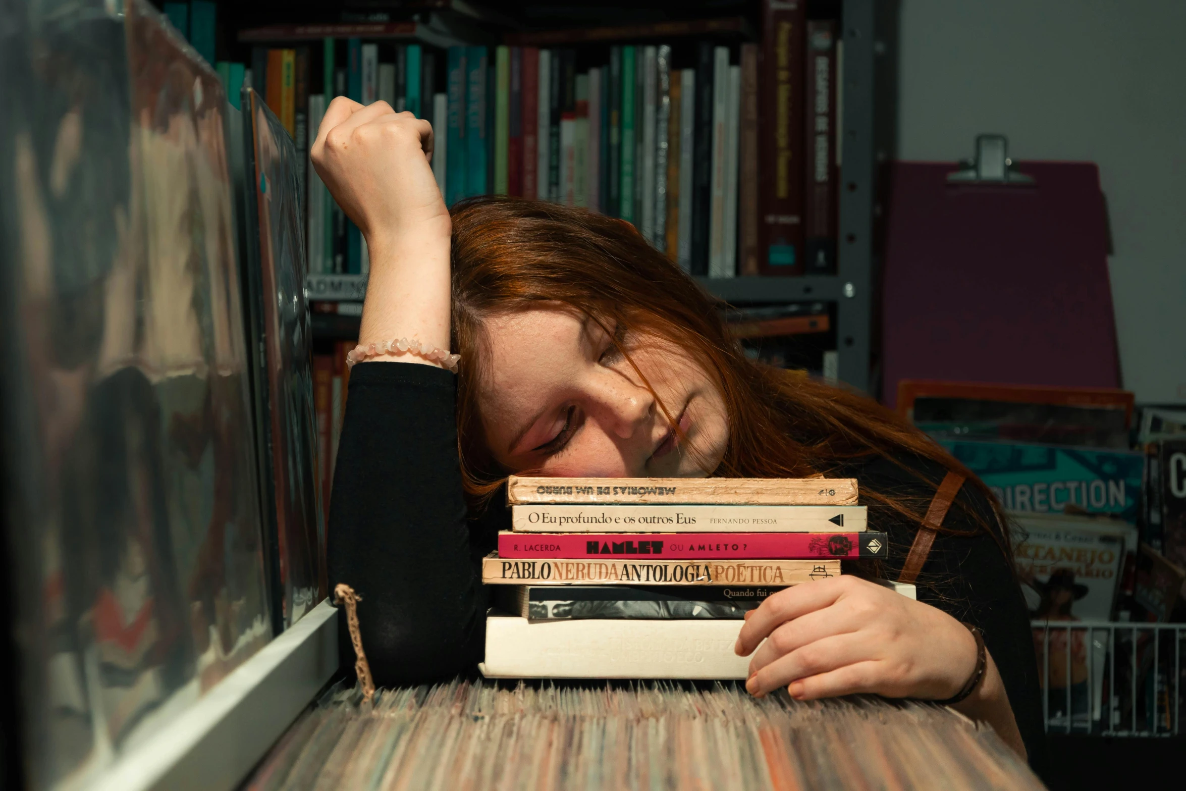 woman laying her head on stacks of books