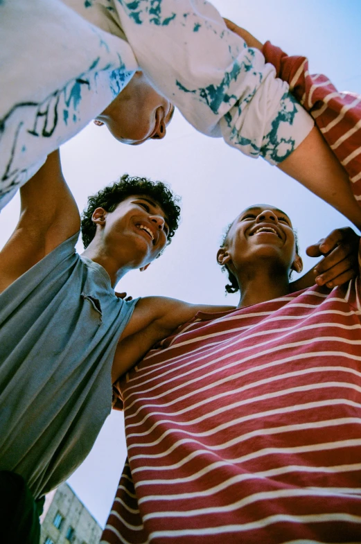 three people in the circle holding their arms around each other