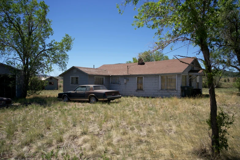 an old pick up truck parked outside a run down house