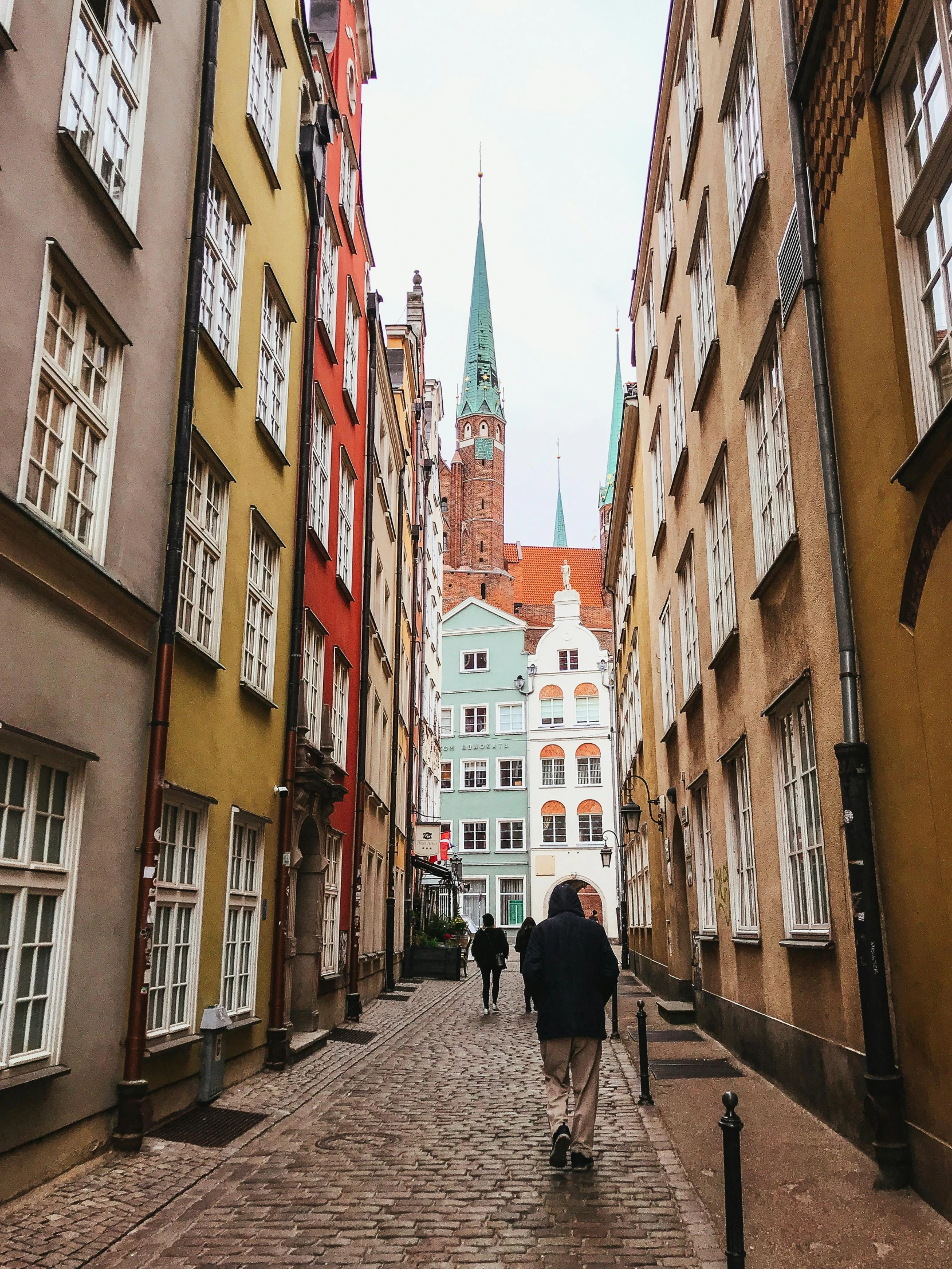 a man is walking along the cobblestone street