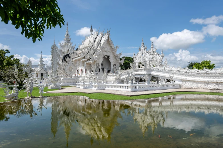 some white statues near some water and trees