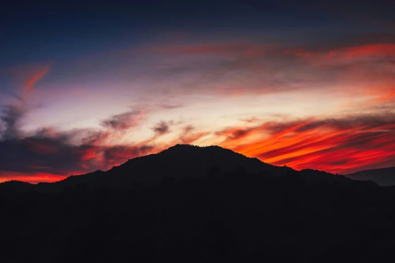 the sky above a mountain covered in clouds