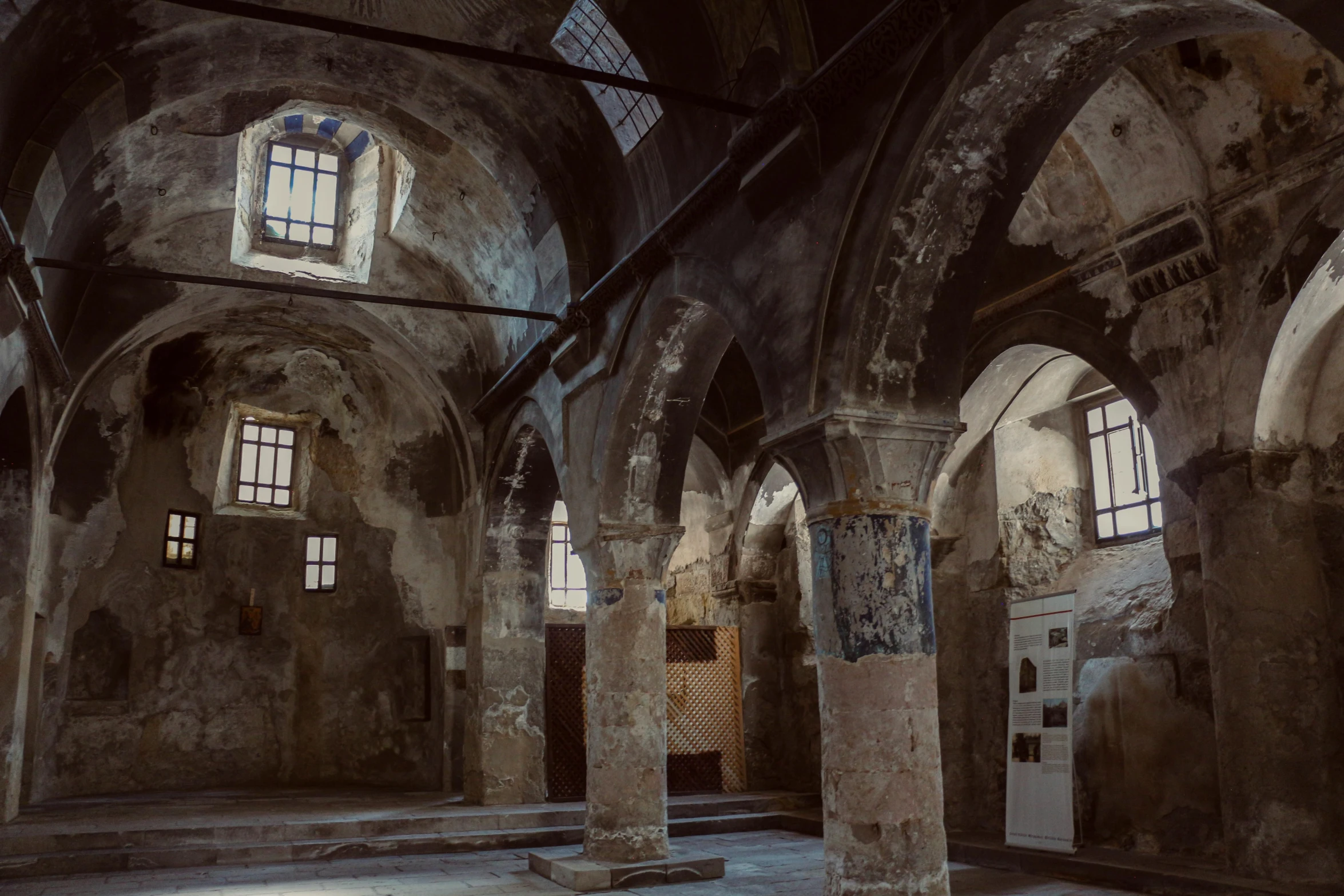 several arched windows with stained glass above the doors