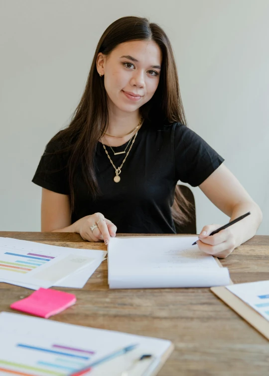 a young lady sitting at a desk taking notes