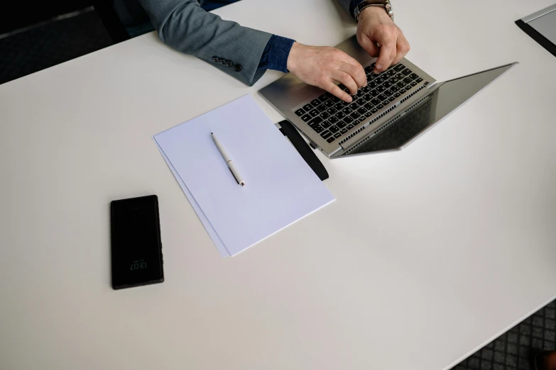 someone's hands on a laptop that is on a table