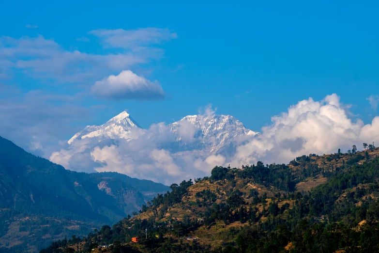 a mountain peak with some clouds above