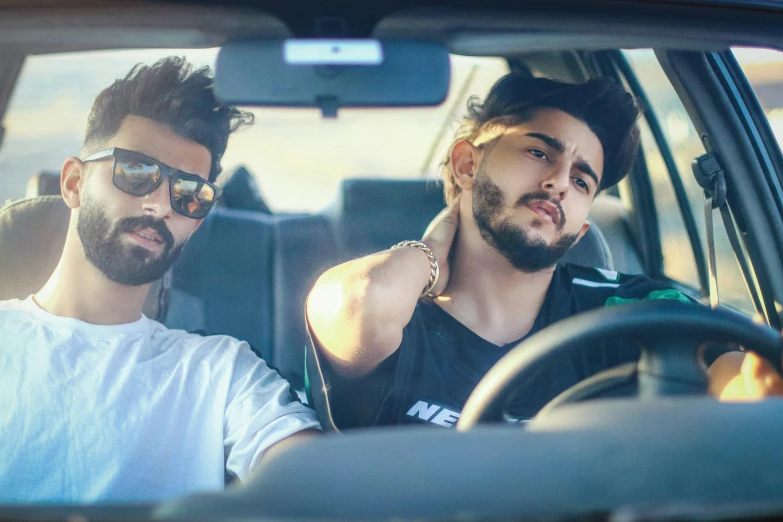 two men sitting in the back seat of a car