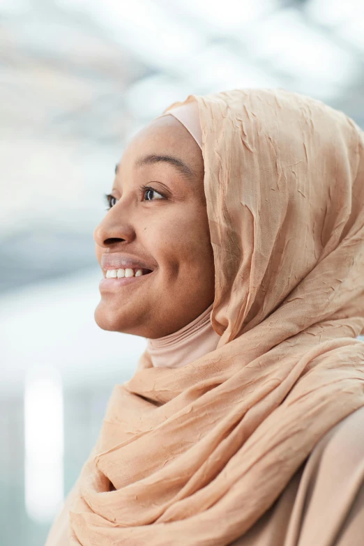 a woman in a headscarf and smile looking at the camera