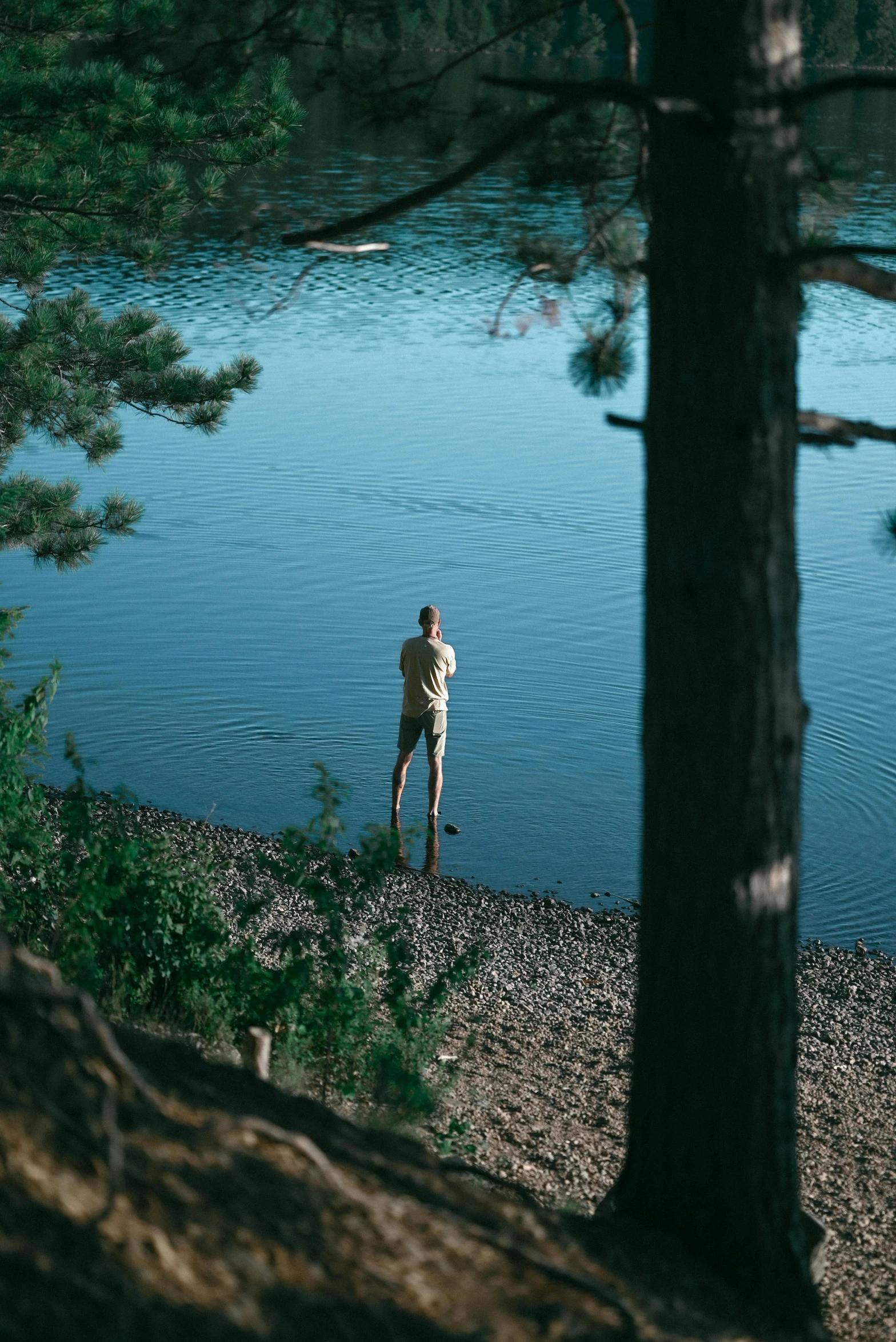 there is a man standing by a river looking at soing