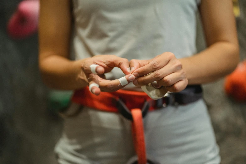 the woman is holding the cigarette and wearing a belt