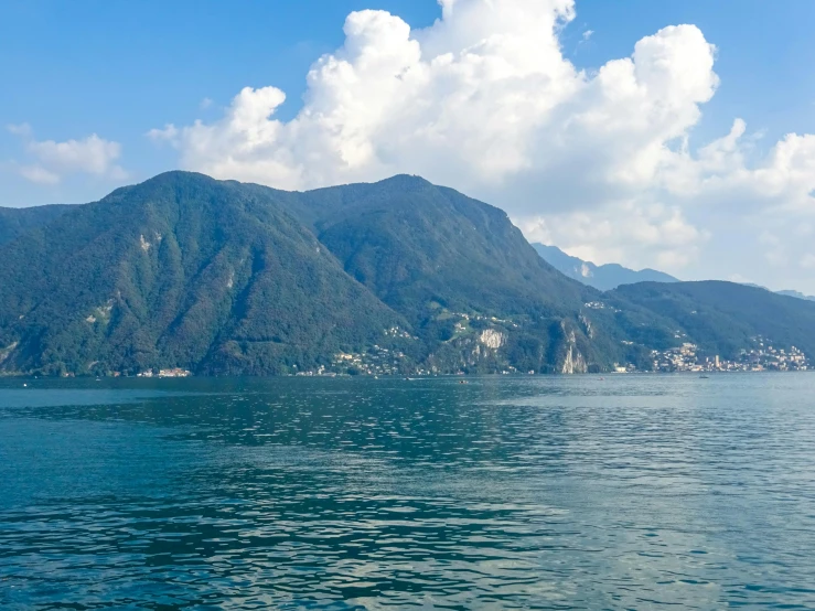 a view of an island on a lake with hills in the background