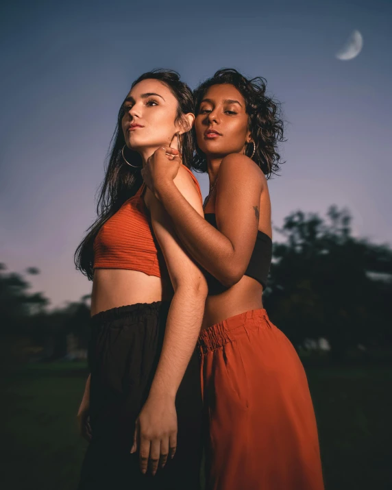 two women in long dress are standing together